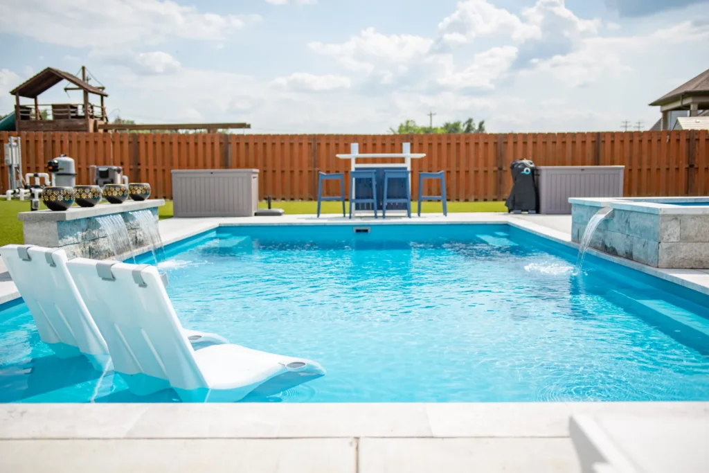 A picture of a McMahan fiberglass pool with a bench in it
